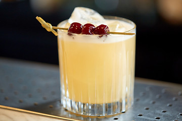 Image showing glass of cocktail with cherries at bar