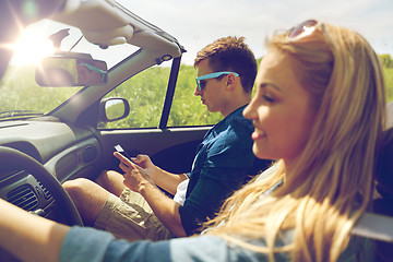 Image showing man texting on smartphone driving in cabriolet car