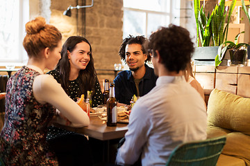 Image showing happy friends eating and drinking at bar or cafe