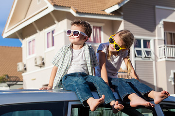 Image showing Happy children getting ready for road trip on a sunny day.