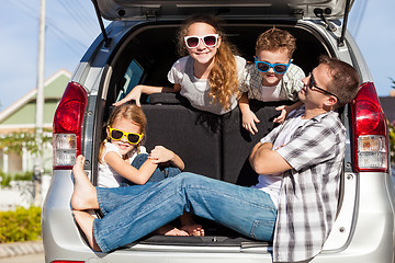 Image showing Happy family getting ready for road trip on a sunny day.