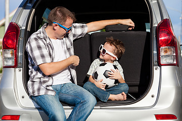 Image showing Happy father and son getting ready for road trip on a sunny day.