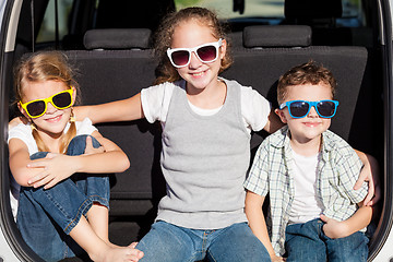 Image showing Happy children getting ready for road trip on a sunny day. 