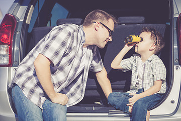 Image showing Happy father and son getting ready for road trip on a sunny day