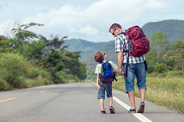 Image showing Father and son walking on the road. 