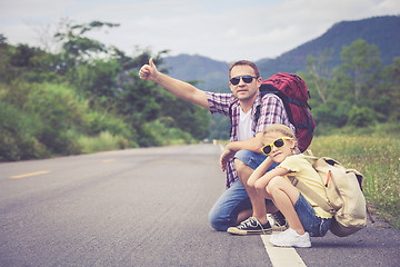 Image showing Father and daughter walking on the road.