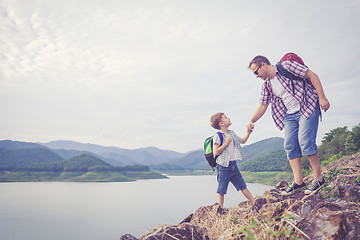 Image showing Father and son standing near the lake.