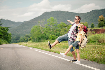 Image showing Father and daughter walking on the road.