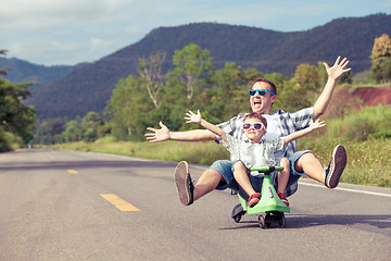 Image showing Father and son playing on the road.