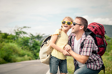 Image showing Father and daughter walking on the road.