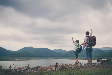 Image showing Father and son standing near the lake.