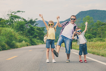 Image showing Father and children walking on the road.