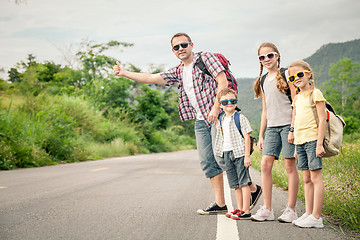 Image showing Father and children walking on the road.