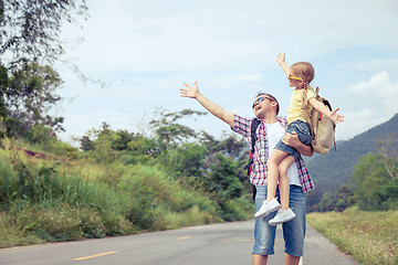 Image showing Father and daughter walking on the road.