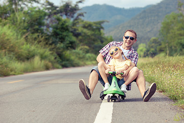 Image showing Father and daughter playing on the road.