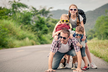 Image showing Father and children walking on the road.