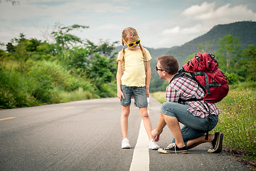 Image showing Father and daughter walking on the road.