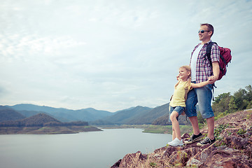 Image showing Father and son standing near the lake.
