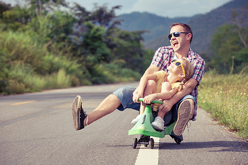 Image showing Father and daughter playing on the road.