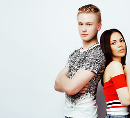 Image showing young pretty teenage couple, hipster guy with his asian girlfriend happy smiling and hugging isolated on white background, lifestyle people concept close up, diverse nations relationship 