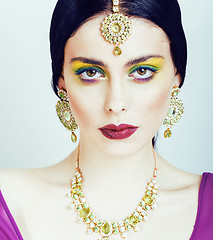 Image showing young pretty caucasian woman like indian in ethnic jewelry close up on white, bridal bright makeup fashion people