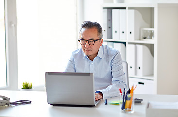 Image showing businessman in eyeglasses with laptop office