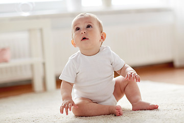 Image showing happy baby boy or girl sitting on floor at home