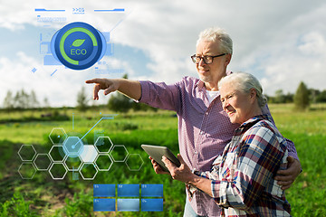 Image showing happy senior couple with tablet pc at summer farm