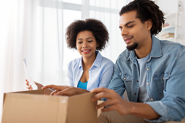 Image showing happy couple with parcel box and paper form home