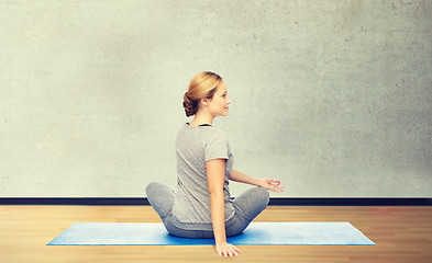 Image showing woman making yoga in twist pose on mat