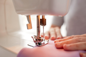 Image showing sewing machine presser foot stitching fabric