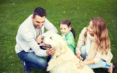 Image showing happy family with labrador retriever dog in park