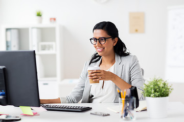 Image showing businesswoman drinking coffee at office computer