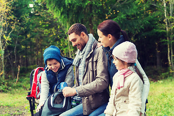 Image showing happy family with backpacks and thermos at camp