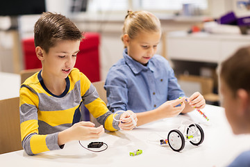 Image showing happy children building robots at robotics school