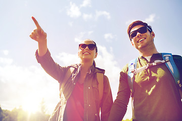 Image showing happy couple with backpacks hiking outdoors