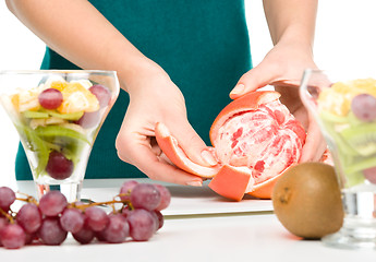 Image showing Cook is peeling grapefruit for fruit dessert