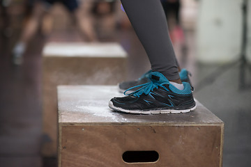 Image showing black woman is performing box jumps at gym