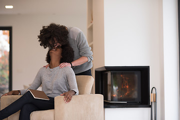 Image showing multiethnic couple hugging in front of fireplace