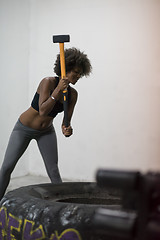 Image showing black woman workout with hammer and tractor tire