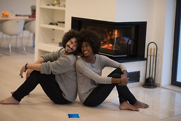 Image showing multiethnic couple with tablet computer on the floor