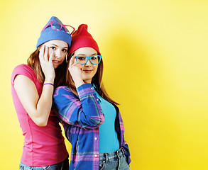 Image showing lifestyle people concept: two pretty young school teenage girls having fun happy smiling on yellow background 