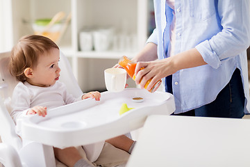 Image showing baby and mother pouring juice to cup at home