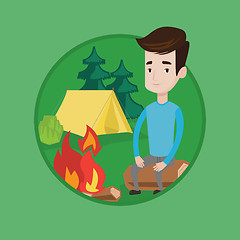 Image showing Man sitting on log near campfire in the camping.