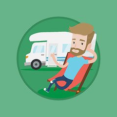 Image showing Man sitting in chair in front of camper van.