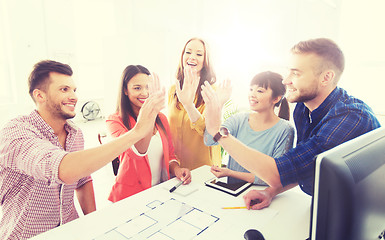 Image showing creative team making high five at office