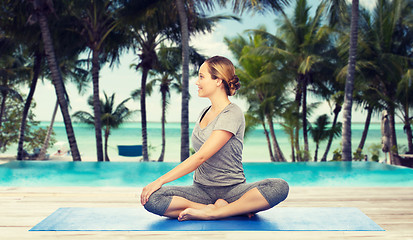 Image showing woman making yoga in twist pose on mat