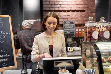 Image showing happy woman or barmaid with cashbox at cafe