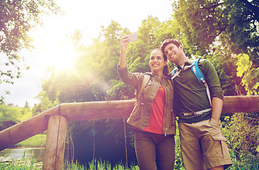 Image showing couple with backpacks taking selfie by smartphone