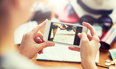 Image showing close up of woman with smartphone and travel stuff